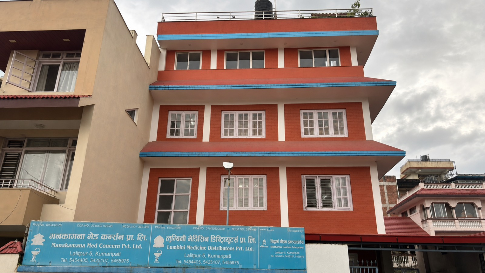 Manakamana Med Concern Pvt. Ltd. office building in Kumaripati, Lalitpur, with group company signs along the front wall.